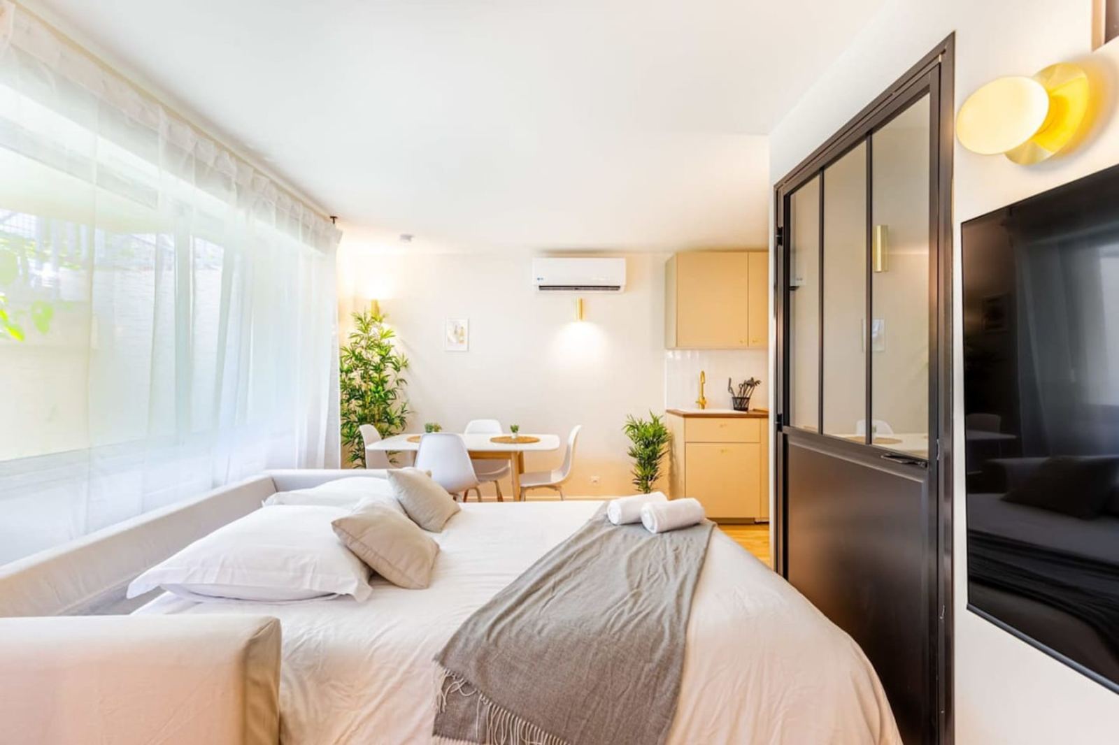 Bedroom with black glass partition in a Lavie Maison serviced apartment in Bordeaux, an alternative to a hotel in the city centre