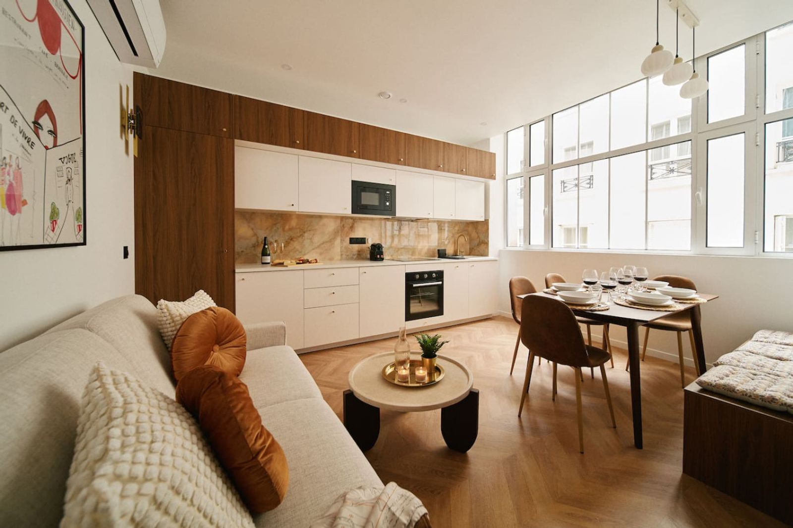 Living room and open kitchen of a Lavie Maison serviced apartment in the Marais, Paris — a spacious alternative to a hotel room